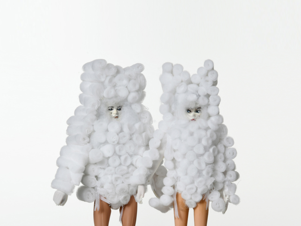 Deux poupées, témoignage d'un design exquis, portent des costumes blancs moelleux, semblables à des nuages, alors qu'elles se tiennent côte à côte sur un fond blanc immaculé. Limbus Studio