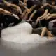 Dans une pose dramatique, la ballerine en tutu blanc est allongée sur scène, entourée de danseurs qui tendent les bras vers elle, créant un tableau vivant qui pourrait sortir tout droit d'un atelier d'art. Limbus Studio