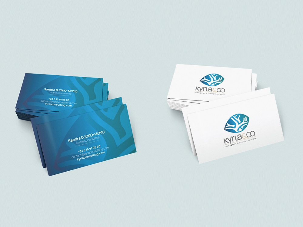 Deux piles de cartes de visite sont disposées avec élégance ; les bleues présentent les coordonnées, tandis que les blanches, conçues comme une pièce de studio créative, arborent un logo élégant et le texte « Kyla & Co. ». Limbus Studio