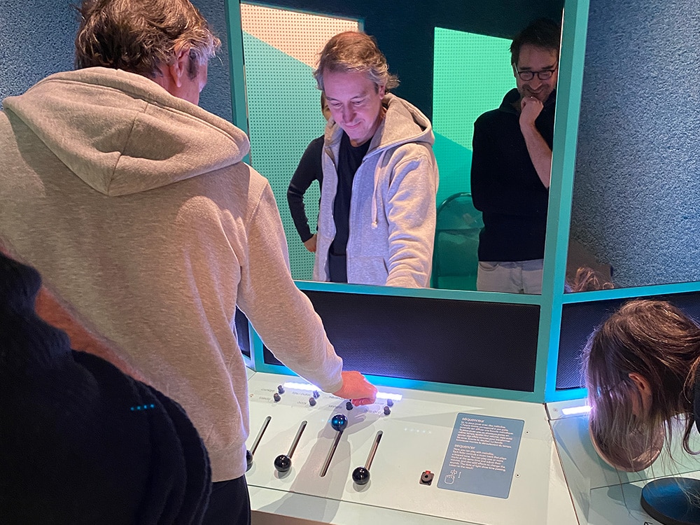 Les visiteurs interagissent avec un panneau de contrôle soigneusement conçu dans l'exposition du musée. Limbus Studio
