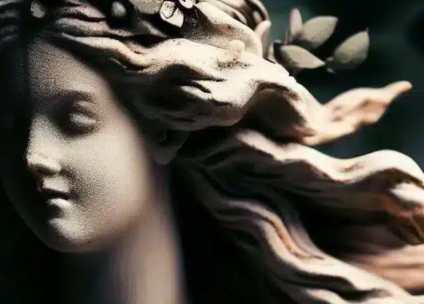 Gros plan d'une sculpture en pierre réalisée dans un atelier renommé, représentant une femme aux cheveux flottants et une couronne de laurier sur la tête. Limbus Studio