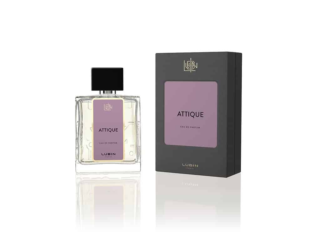Flacon de parfum étiqueté "Attique" avec boîte assortie, présentant un design élégant avec des accents violets et un bouchon noir. Limbus Studio