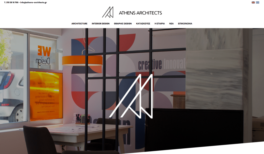 Bureau à la décoration moderne, avec bureau et chaise élégants. Une vitrine présente le texte « We Design » en orange vif et blanc, reflétant l'esprit créatif de notre agence de design. Limbus Studio