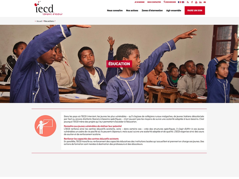 Dans une salle de classe, les enfants lèvent la main avec enthousiasme, incarnant l'esprit de « Éducation », avec le logo de l'IECD fièrement affiché en haut. Le décor respire un design réfléchi, offrant une inspiration proche d'une agence de conception de sites Web créant des expériences numériques engageantes et éducatives. Limbus Studio